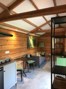 een woonkamer met houten wanden en een bank bij De Túnfûgel (tiny house) in Jonkersland