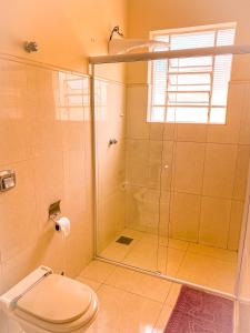 uma casa de banho com um chuveiro e um WC. em Aconchego em Amparo