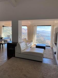 uma sala de estar com um sofá branco e janelas grandes em Villa with unique & breathtaking view over Sea, Monte-Carlo, Italy & Alps em La Turbie