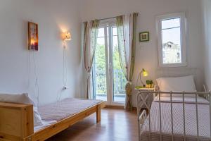 a bedroom with two beds and a large window at Alemar Estates Agia Triada in Agia Triada