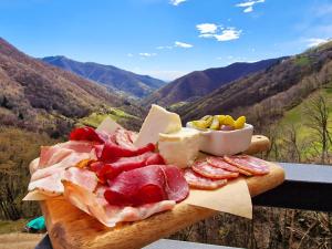 ScudellateにあるOsteria Manciana con Alloggio by Stay Generousのテーブルに肉とチーズを盛り付けたまな板