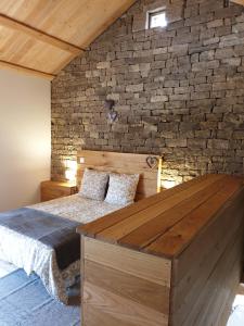 a bedroom with a bed and a brick wall at Les Vergers d'Epona "Fougerolles Haute-Saône" in Fougerolles