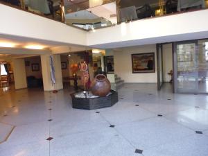 a lobby with a large vase in the middle of it at Provincial Plaza Hotel in Salta