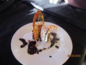 biały talerz z kawałkiem ciasta na stole w obiekcie Beulah-land Hotel and Retreat Center w mieście Mogoditshane