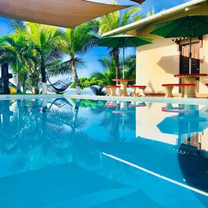 uma piscina com palmeiras e um resort em Big Daddy's Beach Club & Hotel em Puerto Armuelles