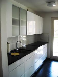 eine Küche mit weißen Schränken und einer Spüle in der Unterkunft Ferienwohnung Baabe in Baabe