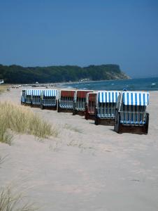 a row of benches sitting on the beach at Ferienwohnung Baabe in Baabe