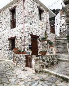 a stone building with a door and stairs in front at Mirthia Apartments in Plakias