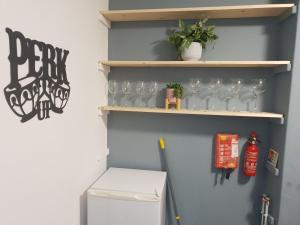una cocina con nevera y estanterías con copas de vino en Topzy-Turvy - 1 Bedroom Apartment en Swansea