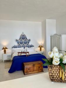 a bedroom with a blue and white bed and a table at Villa Neptunus in Ischia