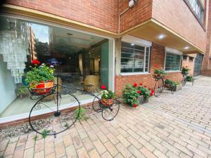 a bike parked in front of a building with flowers at Hotel Retiro 84 in Bogotá