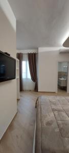 a large white room with a flat screen tv at Casa Francesca e Rooms in Santa Maria di Castellabate