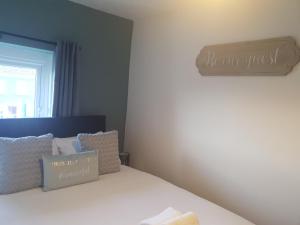 a bedroom with a bed with a sign on the wall at Topzy-Turvy - 1 Bedroom Apartment in Swansea
