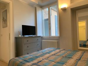 een slaapkamer met een bed en een tv op een dressoir bij Bilocale di Ringhiera in Corso Como/Garibaldi in Milaan