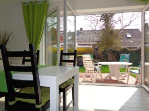 a patio with chairs and a table and a table at Ostfrieslands Perle Ferienwohnung an der Nordseeküste, Sauna, Terrasse, Garten, ruhige Lage, WLAN in Norden