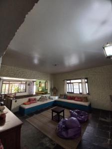 a living room with a blue couch and windows at Rock n Hostel in Cabo Frio