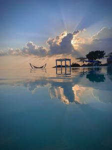 a person sitting in a hammock in the water with the sunset at Casamediterranea in Sperlonga