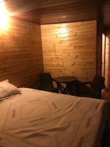 a bedroom with a bed and two chairs in it at Cabaña Los Girasoles in Guatavita +11 photos