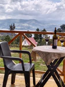 a table with two glasses of wine on a deck at Cabaña Los Girasoles in Guatavita