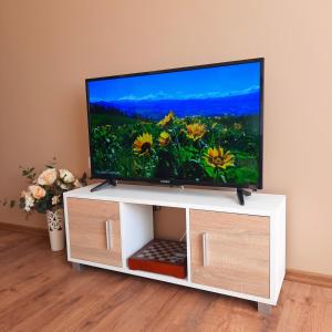 a flat screen tv sitting on a white entertainment center at Апартамент Лидия in Chepelare