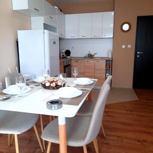 a kitchen with a table with chairs and a white tableablish at Апартамент Лидия in Chepelare +18 photos