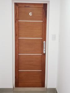 een houten deur met de letter c erop bij Depto Guemes in Salta