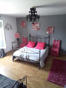 - une chambre dotée d'un lit avec des oreillers roses dans l'établissement appartement complet 11 la roche racan 37370, à Saint-Paterne-Racan
