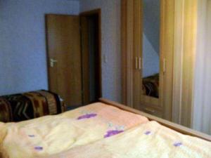 Schlafzimmer mit einem Bett vor einem Spiegel in der Unterkunft Wohnung Lund 2 in Wyk auf Föhr