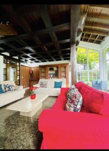 sala de estar con sofá rojo y mesa en María Bonita Chalet Villa independiente con piscina y amplio jardín en Cabezón de la Sal