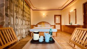 a hotel room with a bed and a tray with drinks on a table at Himalayan adventure Cottages & Budget Friendly BNB Manali in Manāli
