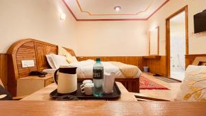 a room with a bed and a bottle on a table at Himalayan adventure Cottages & Budget Friendly BNB Manali in Manāli
