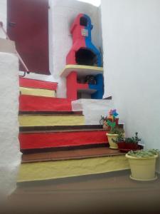 a set of stairs with colorful carpet and potted plants at AL MARE, AL SOLE, SI', ma nella CASA DEL MINATORE in Buggerru