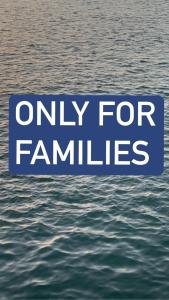 ein blaues Schild, das nur für Familien über dem Wasser steht in der Unterkunft Porto Said chalet for rent بورتوسعيد بورتو سعيد in Port Said