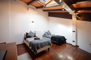[Chardonnay]- elegante appartamento في Cavezzo: سريرين في غرفة بسقوف خشبية