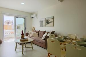ein Wohnzimmer mit einem Sofa und einem Tisch in der Unterkunft Phaedrus Living: City View Fountain Court 113 in Ayia Napa
