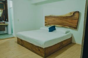 a bed with a wooden headboard in a room at Casa Xalli in Santa María Tonameca