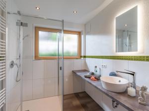 ein Bad mit einem Waschbecken und einer Glasdusche in der Unterkunft Haus Yvonne in Hopfgarten im Brixental