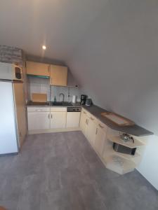 uma pequena cozinha com armários brancos e um frigorífico em Fischerbalje em Borkum