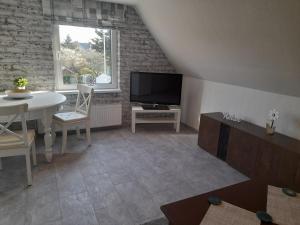 a living room with a white table and a television at Fischerbalje in Borkum