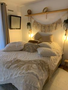 a bedroom with a large bed with white sheets and pillows at Studio tt confort coeur ville avec terrasse et parking gratuit in Sanary-sur-Mer