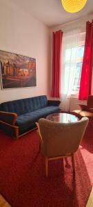 a living room with a blue couch and a glass table at 3Zimmer-Wohnküche-Altbau-90m2-eigener Parkplatz in Oberhausen