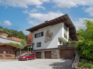 ein Haus mit einem roten Auto, das davor geparkt ist in der Unterkunft Haus Yvonne in Hopfgarten im Brixental