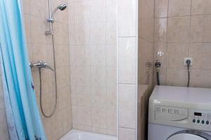 een badkamer met een douche en een wasmachine bij Ferienhaus Meerblick 37 in Glücksburg
