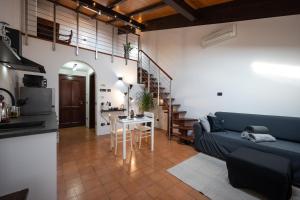 [Chardonnay]- elegante appartamento في Cavezzo: غرفة معيشة مع أريكة زرقاء وطاولة
