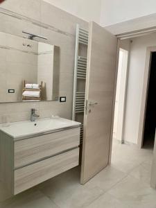 ein Bad mit einem Waschbecken und einem Spiegel in der Unterkunft Civico35 in San Vito dei Normanni