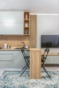 a desk and two chairs in a room with a tv at KOA - NorthSide Apartment in Braşov