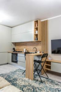 a kitchen with a wooden table and a television at KOA - NorthSide Apartment in Braşov