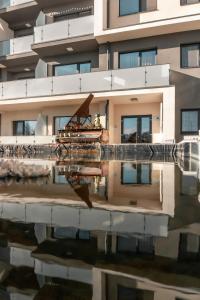 a building with its reflection in a body of water at KOA - NorthSide Apartment in Braşov
