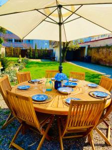 a wooden table with chairs and an umbrella at La Villa Alma Colmar in Colmar +19 photos