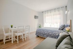 a bedroom with a bed and a table and chairs at Apartment 233 Hispalis Triana in Seville
